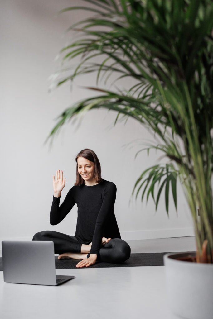 yoga and meditation online, young woman doing fitness in gym with laptop on webcam,